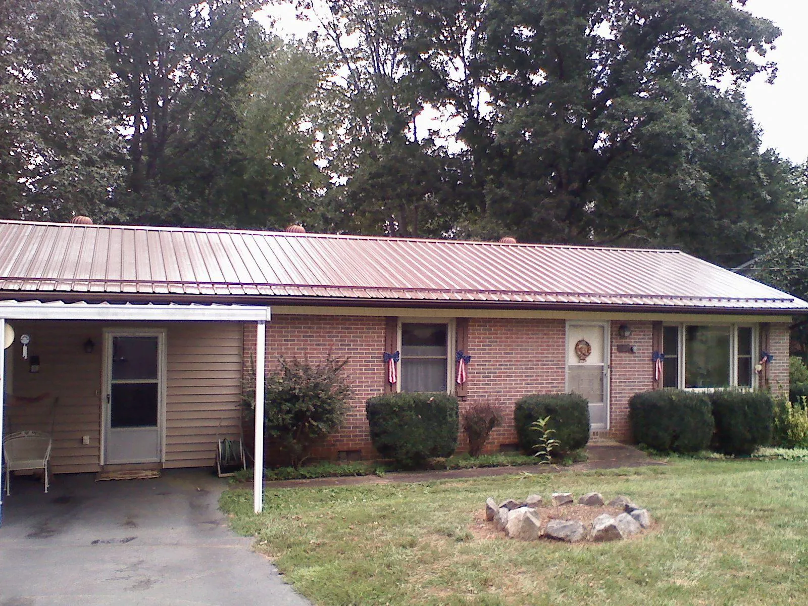 Bronze metal roof and carport on a brick ranch home — Roof Repair work by our crew in Ellenboro